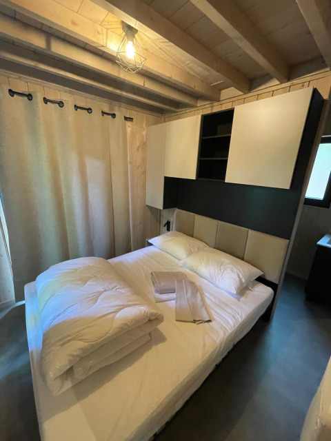 Soveværelse med dobbeltseng og moderne indretning på Eco Lodge, Hameau de l'Ourthe i Belgien.