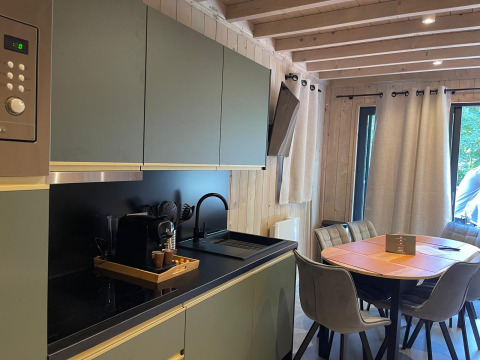 Moderne køkken og spiseområde på Eco Lodge ved Hameau de l'Ourthe i Belgien med naturligt lys.