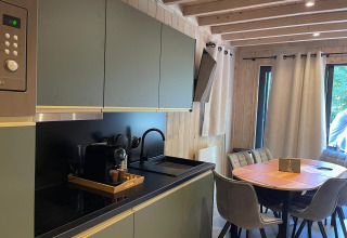Moderne køkken og spiseområde på Eco Lodge ved Hameau de l'Ourthe i Belgien med naturligt lys.