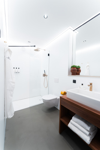 Moderne badkamer in Unbrick One | Sauna bij Brinckerduyn, Nederland met douche, wastafel en houtaccenten.