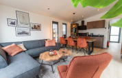 Modern living and kitchen area of Cube Split Hottub lodge at EuroParcs Enkhuizer Strand, Netherlands, stylishly furnished.