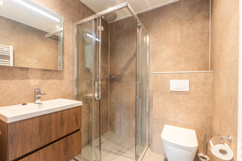 Bagno moderno con doccia in vetro, wc e lavabo presso Cube Split Hottub, EuroParcs Enkhuizer Strand, Paesi Bassi.