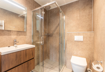 Moderne badkamer met douche, toilet en wasmeubel in Cube Split Hottub aan EuroParcs Enkhuizer Strand, Nederland.