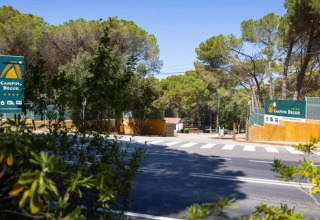 Entrée du Camping Begur en Catalogne, Espagne, avec des panneaux, une route et des arbres en arrière-plan.