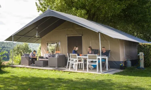 Gezin geniet buiten bij een Begur Safaritent de Luxe met terras op Camping Begur in Spanje