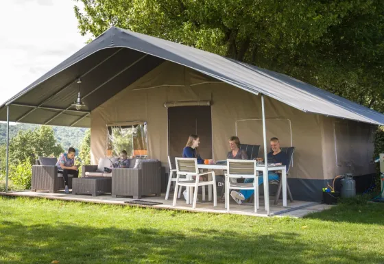 Gezin geniet buiten bij een Begur Safaritent de Luxe met terras op Camping Begur in Spanje
