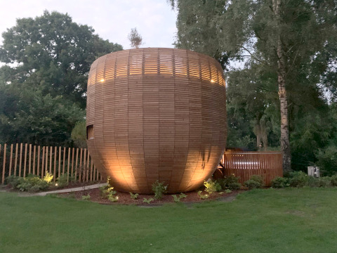 Wood-clad tiny house called The Nutshell with hot tub and sauna at Den Blanken Recreation Park, Netherlands.
