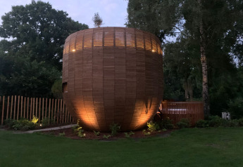 Tiny house en bois The Nutshell avec jacuzzi et sauna au parc de loisirs Den Blanken, aux Pays-Bas, de nuit.
