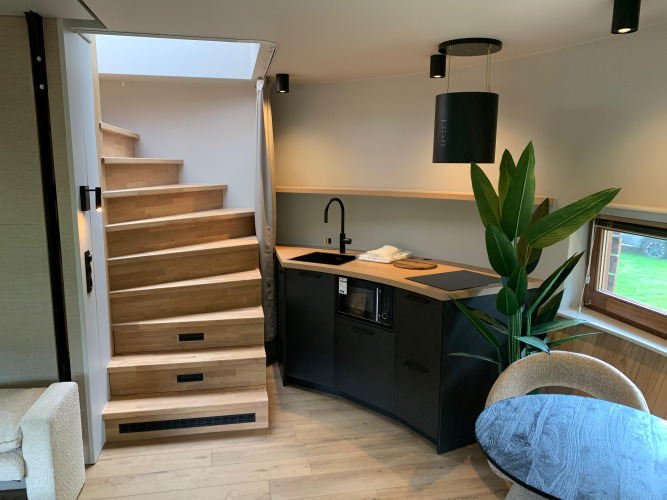 Escalera moderna y cocina compacta en la tiny house The Nutshell en Recreation Park Den Blanken en los Países Bajos.