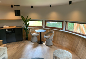 Interieur van The Nutshell tiny house met tafel, stoelen en ramen in Recreation Park Den Blanken.