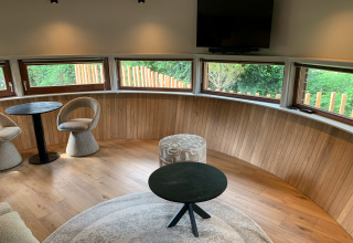 Modern sitting area inside The Nutshell tiny house with hot tub and sauna at Den Blanken Park, Netherlands.