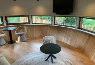 Modern sitting area inside The Nutshell tiny house with hot tub and sauna at Den Blanken Park, Netherlands.