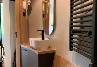 Modern bathroom sink, mirror, and sauna details inside The Nutshell tiny house in Den Blanken, Netherlands.