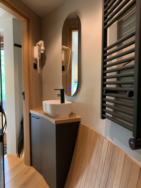Modern bathroom sink, mirror, and sauna details inside The Nutshell tiny house in Den Blanken, Netherlands.