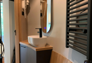 Moderne wastafel en spiegel in The Nutshell tiny house met sauna in Den Blanken, Nederland.