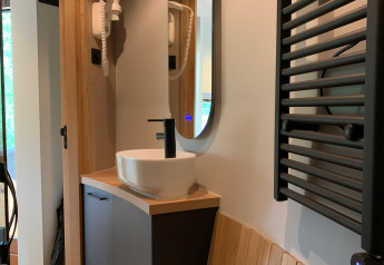Évier et miroir modernes dans la tiny house The Nutshell avec sauna à Den Blanken, Pays-Bas.