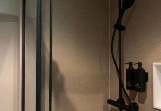 Moderne bruser i et lille hus på Recreation Park Den Blanken, Nederlandene, med regnbruser og sæbepumper.