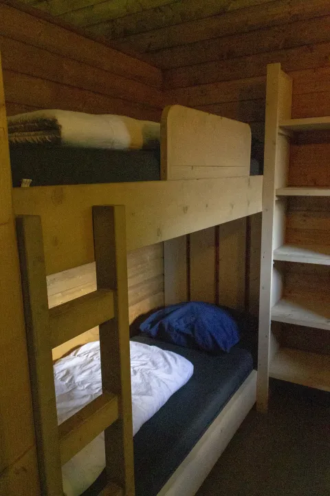 Holzetagenbett und Regal in einem Safarilodge Deluxe-Zelt im Familievakantiepark Krieghuusbelten, Niederlande.