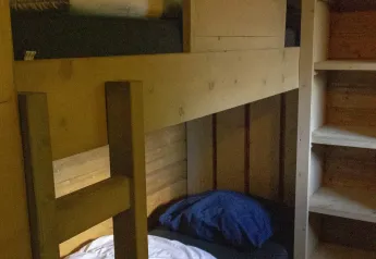 Lit superposé en bois et étagère dans une tente Safarilodge deluxe à Familievakantiepark Krieghuusbelten, Pays-Bas.