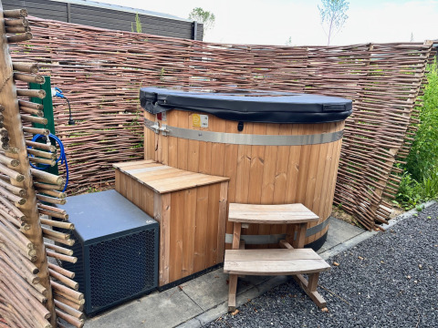 Vasca idromassaggio all'aperto in legno con copertura nera al Cube Split Hottub, EuroParcs Enkhuizer Strand.