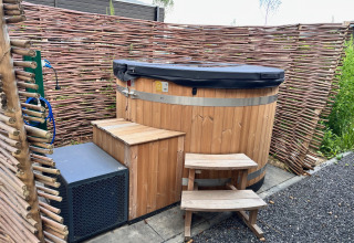 Vasca idromassaggio all'aperto in legno con copertura nera al Cube Split Hottub, EuroParcs Enkhuizer Strand.