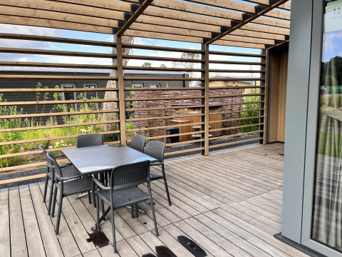 Terrazza esterna al lodge Cube Split Hottub presso EuroParcs Enkhuizer Strand, Paesi Bassi, con tavolo e sedie.
