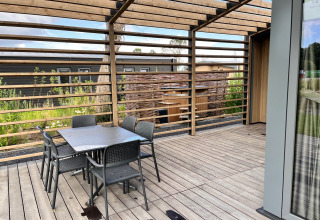 Terrazza esterna al lodge Cube Split Hottub presso EuroParcs Enkhuizer Strand, Paesi Bassi, con tavolo e sedie.
