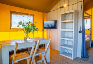 Indvendigt billede af Lodgetent 4 ved Zuiderzee, Holland, med træbord, stole, og hyggelig indretning.