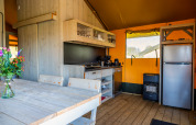 Interiør af safari Lodgetent 4 ved Zuiderzee, Holland, med køkken, spisebord og moderne faciliteter.
