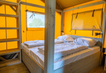 Indvendig udsigt af en Lodgetent 4 safari-telt med dobbeltseng og træindretning på Zuiderzee i Holland.