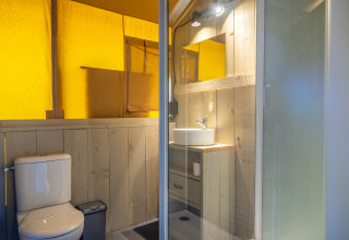 Safari telt badeværelse med træbeklædning, bruser, toilet og håndvask på Lodgetent 4, Zuiderzee, Holland.