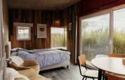 Acogedor dormitorio en Solglimt 4 Pers de Duynpark Het Zwanenwater, Países Bajos, con cama y grandes ventanales.