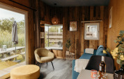 Acogedora cabaña Solglimt 2 Pers. en Duynpark Het Zwanenwater con paredes de madera y vista al exterior.