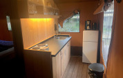 Cozy kitchen area inside Lodgetent Haven 4 at Zuiderzee in the Netherlands, with wooden finishes.