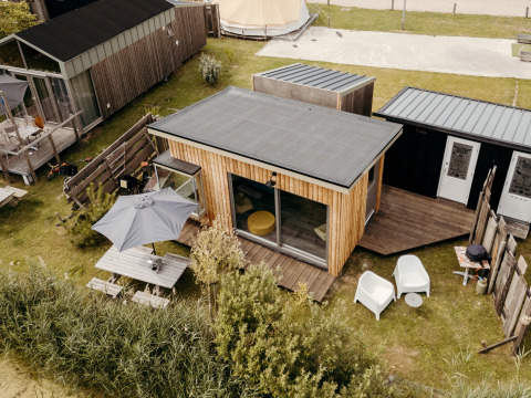 Luchtfoto van lodge Solglimt 2 Pers. op Duynpark Het Zwanenwater in Nederland, met terras en zitplaatsen buiten.