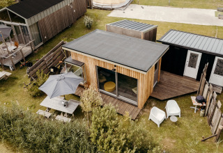 Vista aerea del lodge Solglimt 2 Pers. al Duynpark Het Zwanenwater nei Paesi Bassi, con patio e sedie.