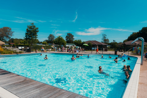 Udendørs swimmingpool fyldt med glade feriegæster på ferieparken De Boshoek i Gelderland, Holland.
