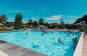 Piscina al aire libre con veraneantes felices en el parque vacacional De Boshoek en Gelderland, Países Bajos.