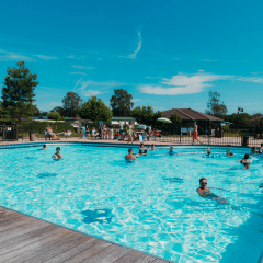 Piscina al aire libre con veraneantes felices en el parque vacacional De Boshoek en Gelderland, Países Bajos.