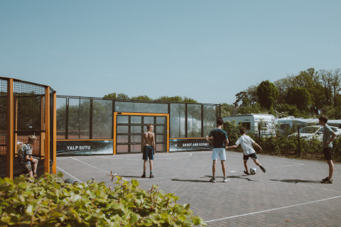 Børn spiller fodbold på en udendørs bane i Holiday park De Boshoek, Gelderland, Nederlandene.