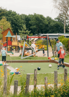 Niños juegan al aire libre cerca de un parque infantil en un complejo vacacional en Gelderland, Países Bajos.