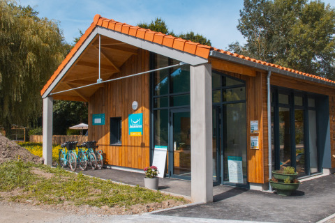 Modern houten gebouw met fietsen vooraan bij Camping Seasonova du Chêne in Pays de la Loire, Frankrijk.