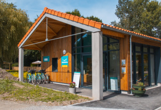 Modern houten gebouw met fietsen vooraan bij Camping Seasonova du Chêne in Pays de la Loire, Frankrijk.