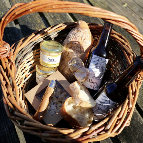 Cestino da picnic con pane, birra, creme e golosità di Domaine des Feuilles in Alvernia-Rodano-Alpi.