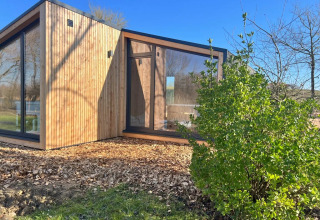 Modernes Holzferienhaus mit großen Fenstern im Domaine des Feuilles, im Grünen in Auvergne-Rhône-Alpes.