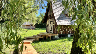 Affascinante baita di legno presso Cabine Fées con passerella immersa in un ambiente verde rigoglioso.