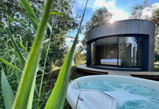 Buitenzicht op ronde Lumipod Spa île-hut met grote ramen en bubbelbad bij Domaine des Feuilles, Frankrijk.