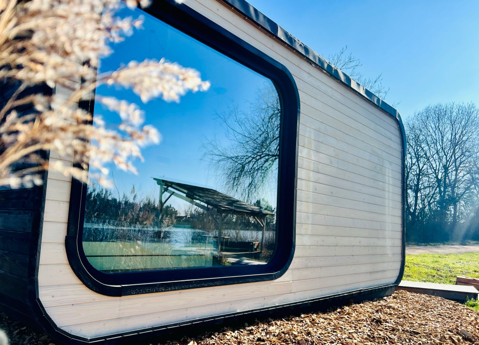 Moderne Roseaux Cabin bij Domaine des Feuilles in Frankrijk, met groot raam en uitzicht op de natuur.