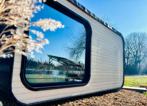 Moderne Roseaux Cabin in Domaine des Feuilles, Frankrijk, met groot raam en uitzicht op het groen.