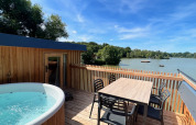 Terrazza all'aperto con vasca idromassaggio e tavolo da pranzo vista lago allo Spa Horizon Cabin, Domaine des Feuilles.